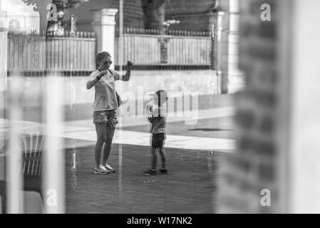 La madre e il bambino in modo nuovo in sfumature e ombre. Noi percepiamo da questa foto che la madre insegna baby alcuni segni che egli cerca di repea Foto Stock