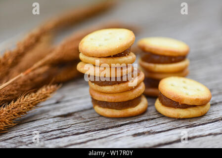 Biscotti con marmellata di ananas / biscotti cookies su legno per snack cracker Foto Stock