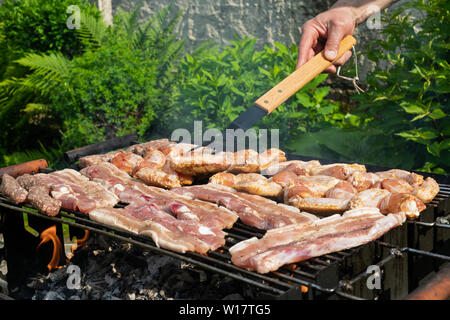 Chiudere l immagine della grigliatura gustosa carne di maiale e di pollo a un barbecue esterno parte Foto Stock