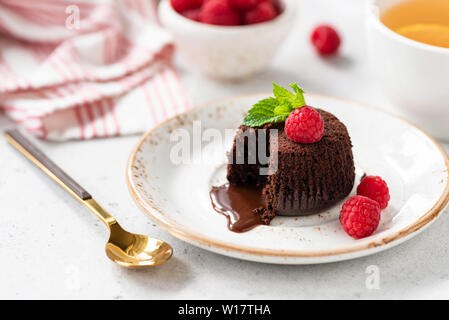Gustosi dessert al cioccolato fondente di lava o torta con lamponi freschi. Primo Piano Foto Stock