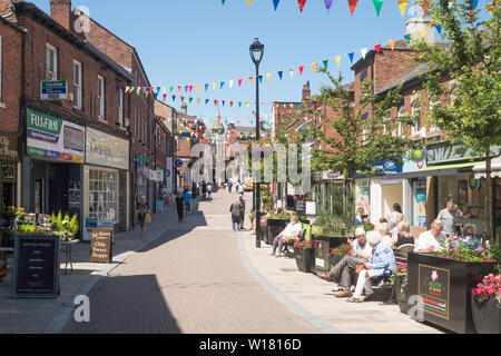 Gli anziani seduti a parlare in Bridge Street, Congleton Town Center, Cheshire, Inghilterra, Regno Unito Foto Stock