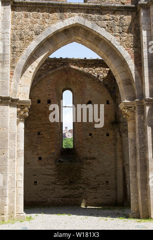 Dettaglio di un arco in abbazia di San Galgano con la visualizzazione della finestra degli edifici più vicina. Colpo verticale. Foto Stock