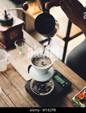 Sgocciolare la produzione di birra, caffè filtrato o pour-over è un metodo che prevede di versare acqua su arrosto, chicchi di caffè macinati contenuta in un filtro. Foto Stock