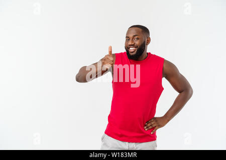 Giovane americano africano uomo su sfondo isolato indossando sport usura sorridente con la faccia felice guardando con il pollice verso l'alto. Foto Stock