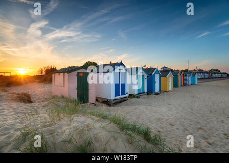 Tramonto su una fila di cabine sulla spiaggia, a Southwold sulla costa di Suffolk Foto Stock