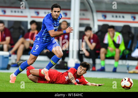 Italian-Brazilian calciatore Eder Citadin Martins, noto semplicemente come Eder, sinistra, di Jiangsu Suning passa la palla contro un giocatore di Tianjin Tianhai nel loro quindicesimo round corrispondere durante il 2019 Chinese Football Association Super League (CSL) di Tianjin, Cina, 30 giugno 2019. Jiangsu Suning giocato disegnare a Tianjin Tianhai 2-2. Foto Stock