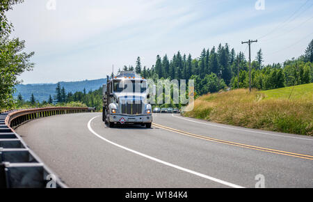 Big Rig potente del cofano di grado industriale professionale semi carrello il trasporto di liquidi infiammabili e il combustibile nel serbatoio semirimorchi in esecuzione sul giro di Foto Stock