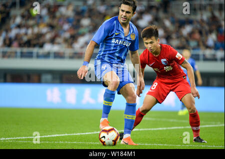 Italian-Brazilian calciatore Eder Citadin Martins, noto semplicemente come Eder, sinistra, di Jiangsu Suning passa la palla contro un giocatore di Tianjin Tianhai nel loro quindicesimo round corrispondere durante il 2019 Chinese Football Association Super League (CSL) di Tianjin, Cina, 30 giugno 2019. Jiangsu Suning giocato disegnare a Tianjin Tianhai 2-2. Foto Stock