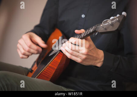 Musica folk russa sfondo. Le mani di un uomo giocando balalaika, close-up foto con messa a fuoco selettiva Foto Stock