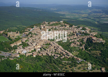 VISTA AEREA. Borgo medievale in cima alla collina che domina i terreni agricoli della Val d'Orcia. Montalcino, Provincia di Siena, Toscana, Italia. Foto Stock