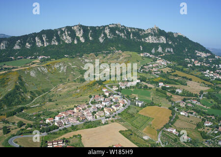 VISTA AEREA. Monte Titano (altitudine: 749m, punto più alto del paese) si affaccia su un paesaggio di terreni agricoli e borghi. Repubblica di San Marino. Foto Stock