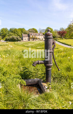 Una vecchia pompa acqua nel villaggio Costwold poco Barrington, GLOUCESTERSHIRE REGNO UNITO Foto Stock