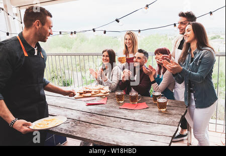 Felice gruppo di amici a bere birra e mangiare la pizza al bar birreria ristorante. concetto con i giovani avendo divertimento genuino Foto Stock