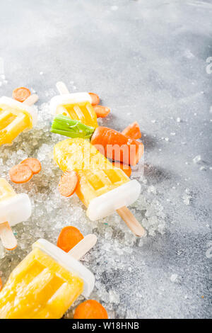 Gelato vegetale. Carota Vegan gelato popsicles con organici carotine, vecchio rustico sfondo di legno. Foto Stock