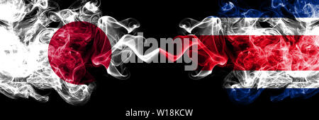 Giappone vs Costa Rica smoky mystic bandiere poste fianco a fianco. Spessa colorata fumi setosa combinazione di Costa Rica e Bandiera giapponese Foto Stock