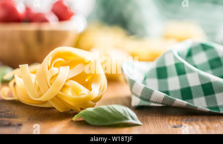 La pasta italiana Le tagliatelle su tavola con basilico e pomodori Foto Stock