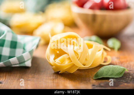La pasta italiana Le tagliatelle su tavola con basilico e pomodori Foto Stock