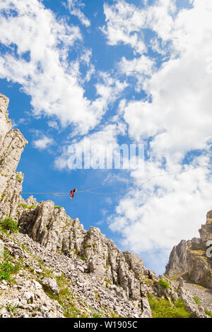 Giovane uomo su un highline sopra sharp scogliere frastagliate Foto Stock