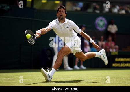 Novak Djokovic in azione il giorno uno dei campionati di Wimbledon al All England Lawn Tennis e Croquet Club, Wimbledon. Foto Stock