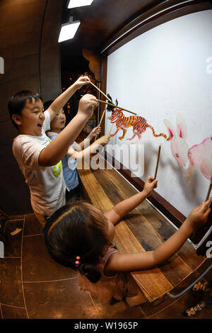 Tangshan cinese nella provincia di Hebei. Il 30 giugno, 2019. I bambini giocano con shadow puppets presso un museo in Tangshan, nel nord della Cina di nella provincia di Hebei, 30 giugno 2019. Credito: Liu Mancang/Xinhua/Alamy Live News Foto Stock