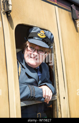 Kidderminster, Regno Unito. 29 giugno 2019. Severn Valley Railways 'Start to the 1940's' si avvia in modo favoloso questo fine settimana estivo con re-enactor in costume che svolgono la loro parte nel fornire un'autentica ricreazione della Gran Bretagna in tempo di guerra. Donna in uniforme RAF si affaccia su una carrozza ferroviaria d'epoca che guarda fuori dalla finestra del treno. Credito: Lee Hudson Foto Stock
