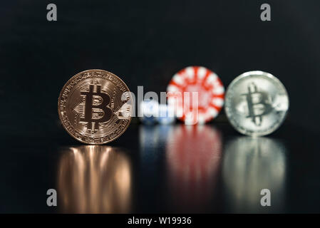 Bitcoins su uno sfondo nero con cubetti di gioco. Foto Stock