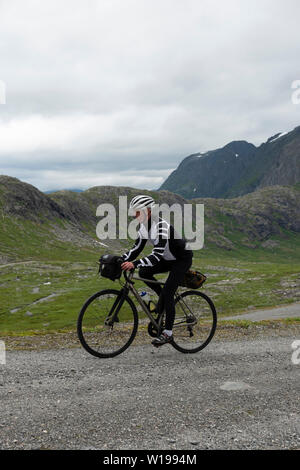 Ciclista maschio privato sulla strada a pedaggio attraverso Vengedalen, vicino ad Andalsnes, Norvegia. Foto Stock