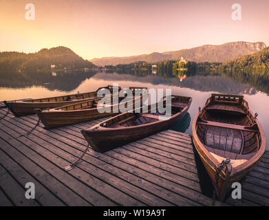 Panorama mozzafiato del lago di Bled in Slovenia - tradizionale Pletna barche all'alba sullo sfondo. Il lago di Bled è un luogo famoso e popolare europea viaggio d Foto Stock