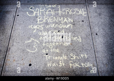 Un Chalk memorial segno sul marciapiede opposto al sito del triangolo Shirt fabbrica di cintura su Washington Pl. nel Greenwich Village di New York City. Foto Stock