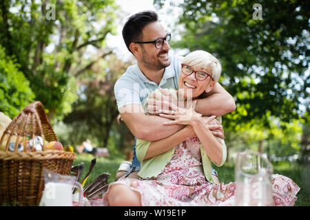 Felice la nonna con nipote abbracciando in un parco all'aperto Foto Stock