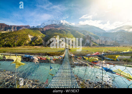 Ponte di sospensione con la preghiera buddista bandiere Foto Stock