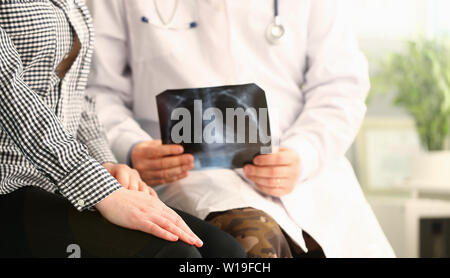 Medico paziente tiene x-ray e relazioni cattive notizie Foto Stock