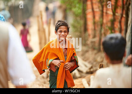 Ragazzo a piedi lungo una strada di Rohingya Refugee Camp Kutupalong, Bangladesh Foto Stock