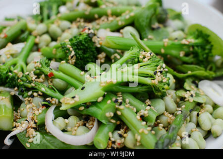 Broccolini, Francese fagioli e fave in un insalata fresca, e condito con olio e sesamo e nigella semi Foto Stock