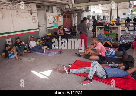 Matamoros, Messico. Il 30 giugno, 2019. Un gruppo di cubani è in attesa di essere chiamato dalle autorità americane ad avviare la procedura di asilo. Centinaia di migranti sono in attesa vicino alla Puerta internazionale Ponte del Messico per chiedere asilo negli Stati Uniti. L'atmosfera è disperata come molti migranti vivere all'aperto in mezzo alle alte temperature che prevalgono nella Comunità sul Messico settentrionale, al confine. Credito: Carlos Ogaz/dpa/Alamy Live News Foto Stock