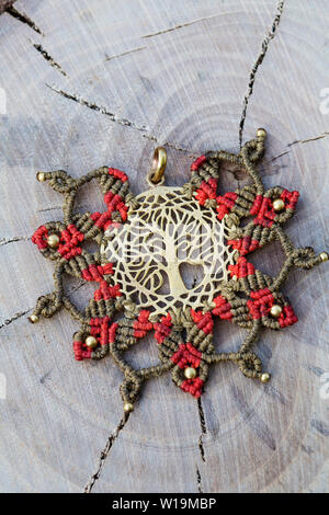 Ottone pendente in metallo con tecnica macrame Gioielleria Ciondolo su sfondo di legno Foto Stock