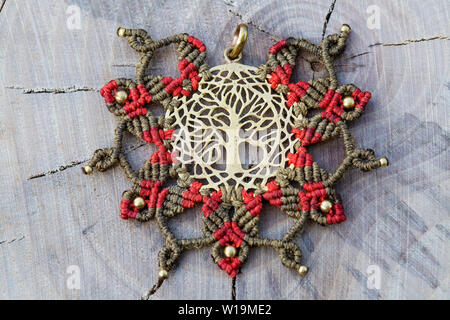 Ottone pendente in metallo con tecnica macrame Gioielleria Ciondolo su sfondo di legno Foto Stock