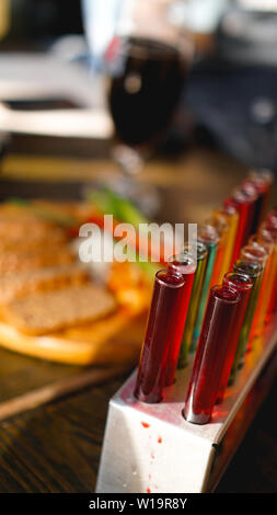 Provette con multi-liquido colorato. Alcool in tubi di prova barra scura. Foto dal bar a Lviv Ucraina Foto Stock