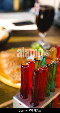 Provette con multi-liquido colorato. Alcool in tubi di prova barra scura. Foto dal bar a Lviv Ucraina Foto Stock