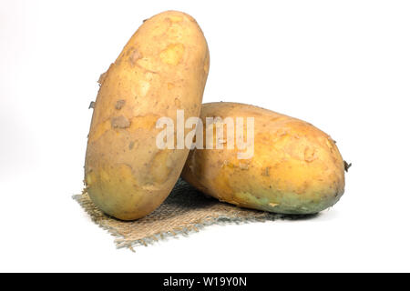 Materie, non lavate e con la buccia di patate su una piazza di hessian isolato su bianco Foto Stock