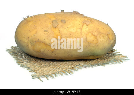 Raw, unwashed, patate con la buccia su un quadrato di hessian isolato su bianco Foto Stock