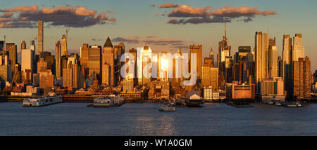 New York City tramonto su Midtown West e i suoi grattacieli. Vista panoramica dei piloni lungo il fiume Hudson. Manhattan, STATI UNITI D'AMERICA Foto Stock
