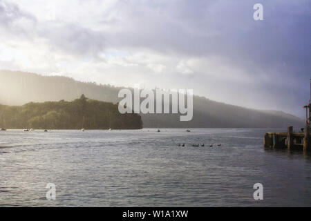 Un panorama molto suggestivo del Lago di Windermere durante un acquazzone di luce con alcuni raggi del sole filtrare attraverso le nuvole. Parco Nazionale del Distretto dei Laghi. Foto Stock