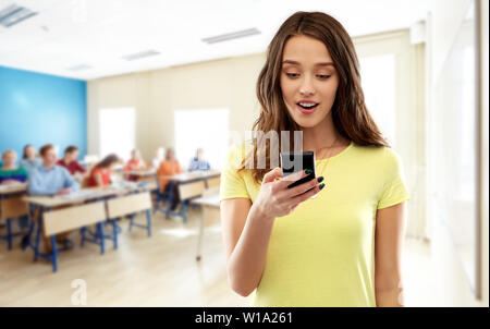 Teenage ragazza studente utilizza lo smartphone a scuola Foto Stock