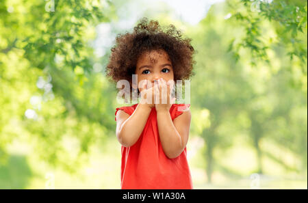 Confuso African American Girl bocca di copertura Foto Stock