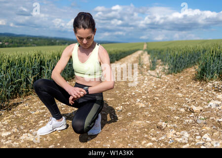 Pareggiatore donna controllando il suo smart watch Foto Stock
