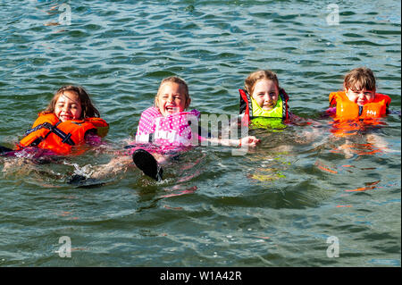 Baltimore, West Cork, Irlanda. 1 Luglio, 2019. Come temperature hit tardo teens su una bella giornata di sole, i turisti e la gente del posto ha avuto la possibilità di rinfrescarvi nell'acqua. Questi giovani ragazze appena rilassati in acqua. Credito: Andy Gibson/Alamy Live News. Foto Stock