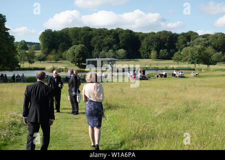 Garsington Opera; operagoers passeggiate all'aperto nei giardini prima delle opere; Garsington, Wormsley station wagon, Stokenchurch, Buckinghamshire England Regno Unito Foto Stock