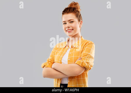 Sorridente dai capelli rossi ragazza adolescente con bracci incrociati Foto Stock