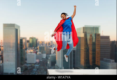 Felice African American woman in supereroe red cape Foto Stock